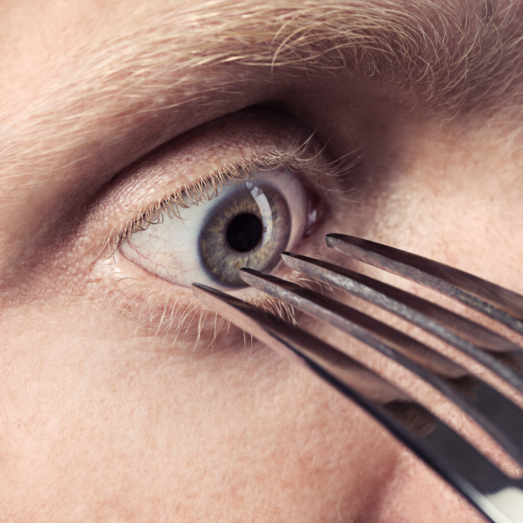 man sticking fork near his eye